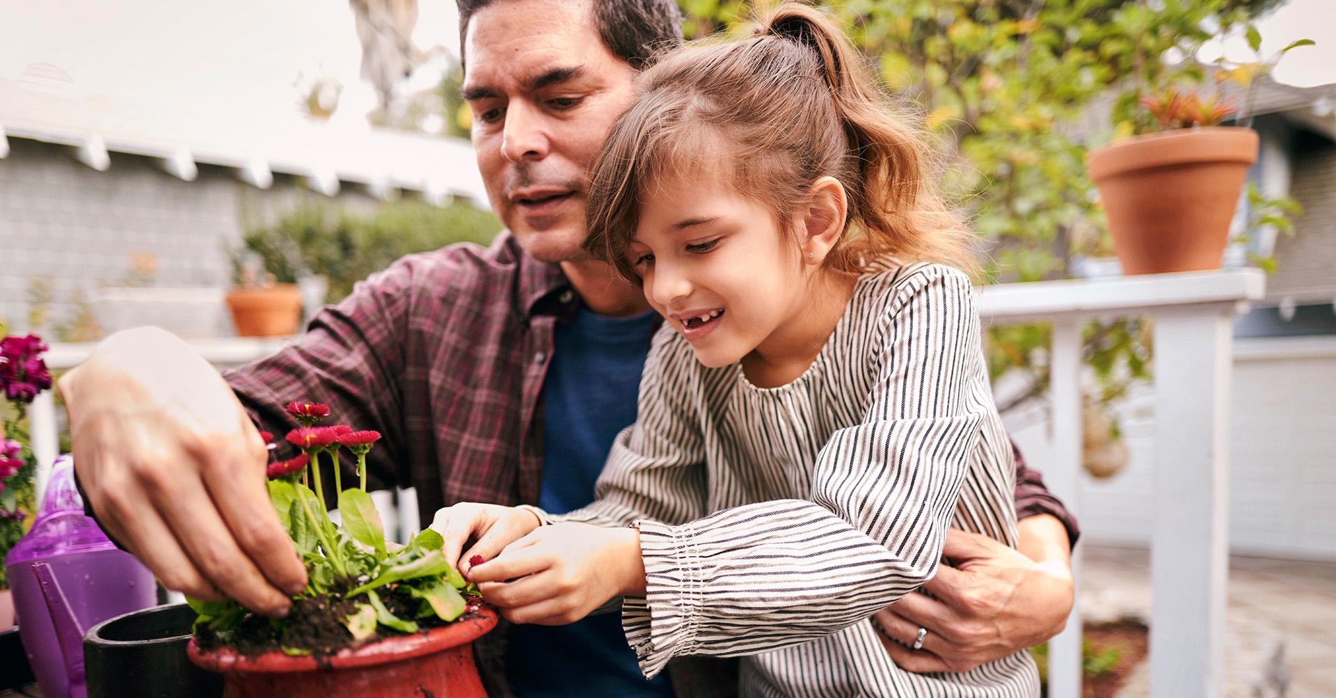Father and daughter potting a plant.