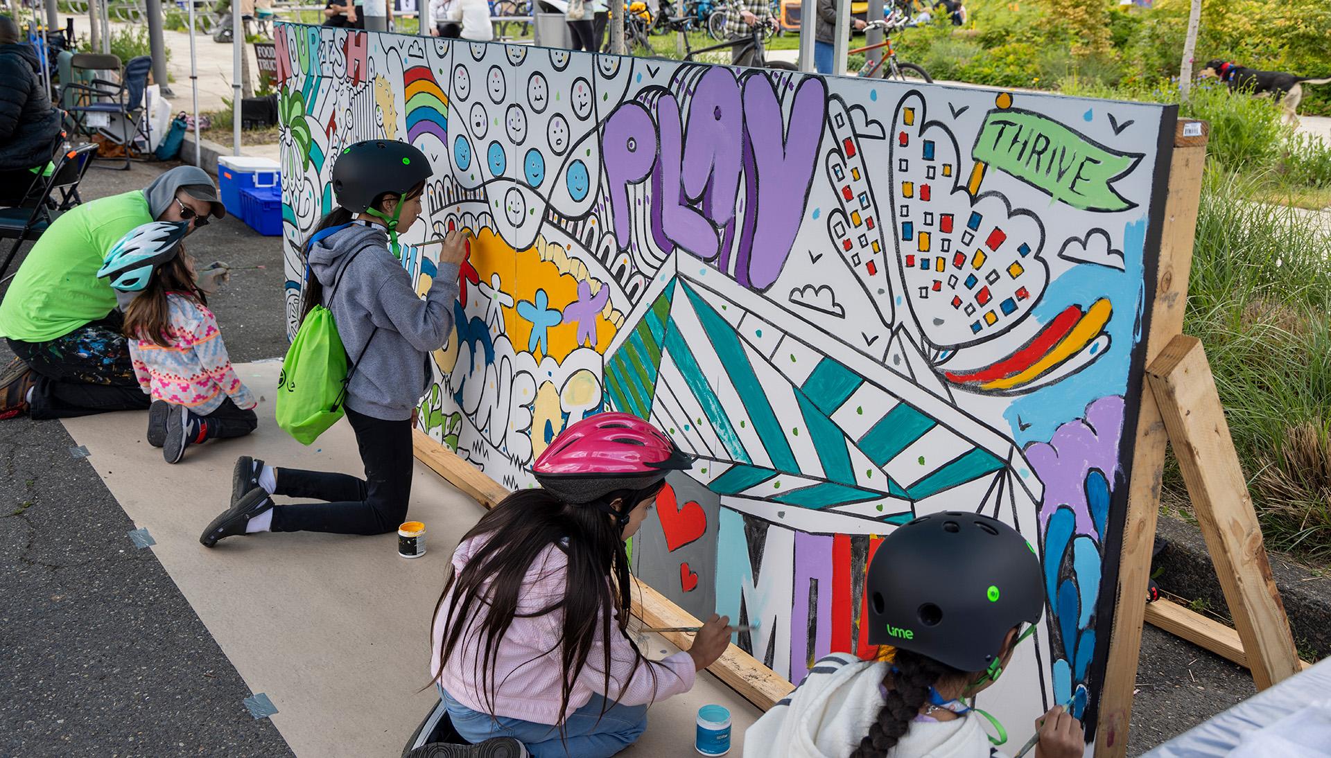Sunday Parkway participant painting community mural.